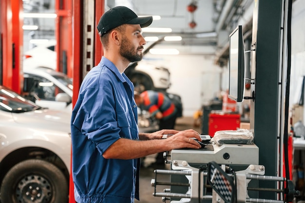 Professionelle Fahrzeuginspection, moderne Werkstatt, Techniker mit Diagnoseequipment